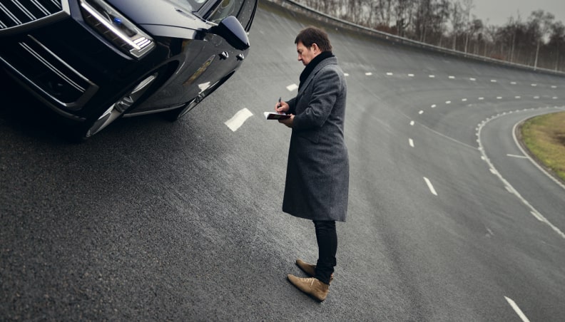Frank Paul Janssen standing in the middle of a steep turn next to a car